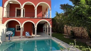 Un edificio di due piani con una piscina di fronte.