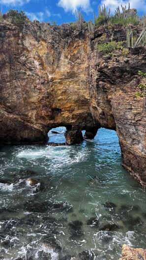 A natural rock formation with a water passage.