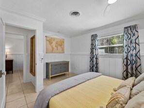 Un dormitorio con cama, cómoda y un mapa del mundo en la pared.
