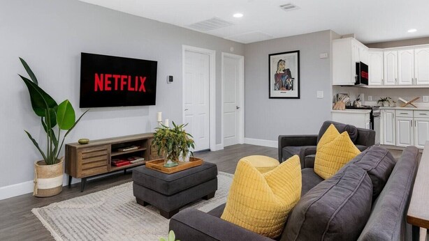 A modern living room with a flat-screen TV, a grey sofa, and a coffee table. - Bella| Pool/Spa|Downtown|Freeways|Beaches (San Diego)
