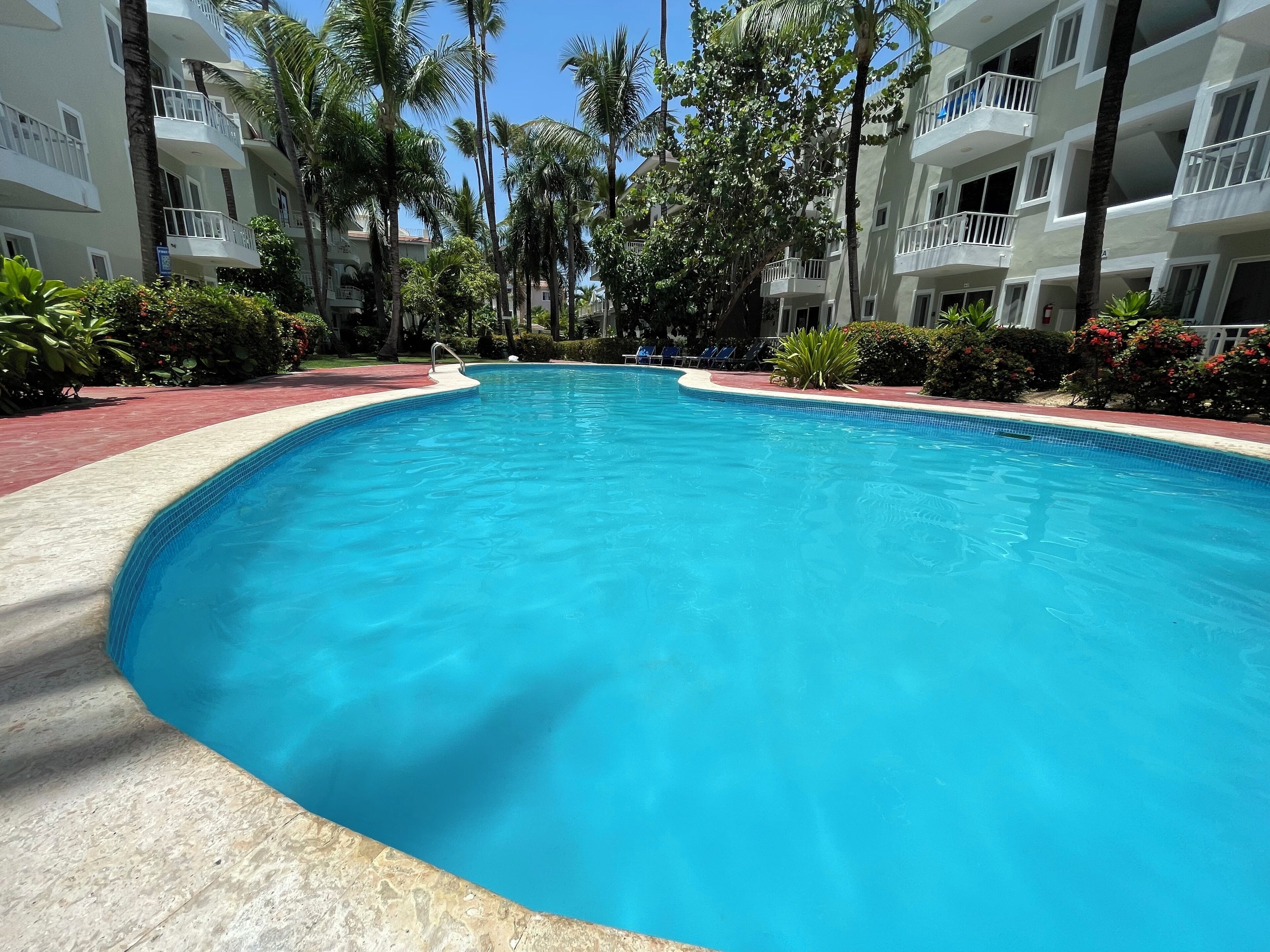 Een buitenzwembad, parasols voor strand/zwembad