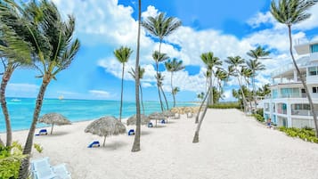 Am Strand, weißer Sandstrand, Liegestühle, Sonnenschirme