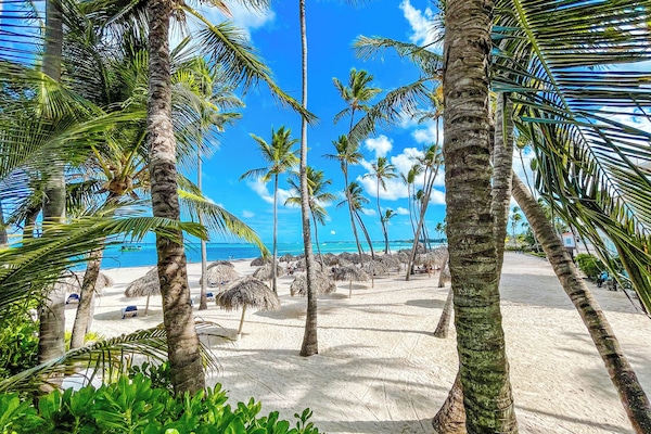 Di pantai, pasir putih, kerusi lepak pantai, payung