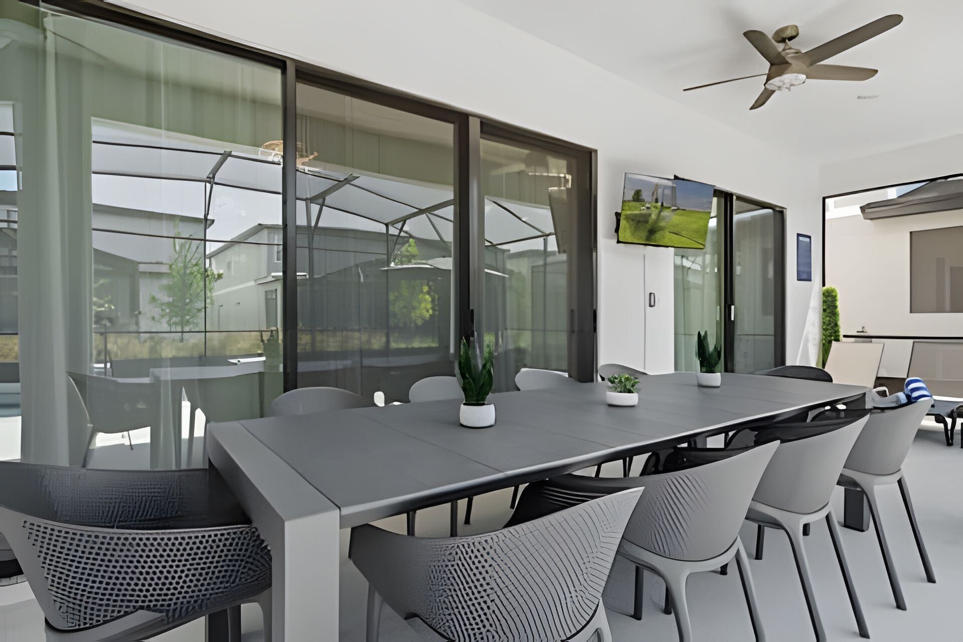 Una sala de reuniones moderna con una mesa larga, sillas y un ventilador de techo.