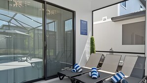 A modern lounge area with glass walls, a pool, and a minimalist design. - Luxurious 9BR Paradiso Pool, Cinema & Game Room (Orlando)