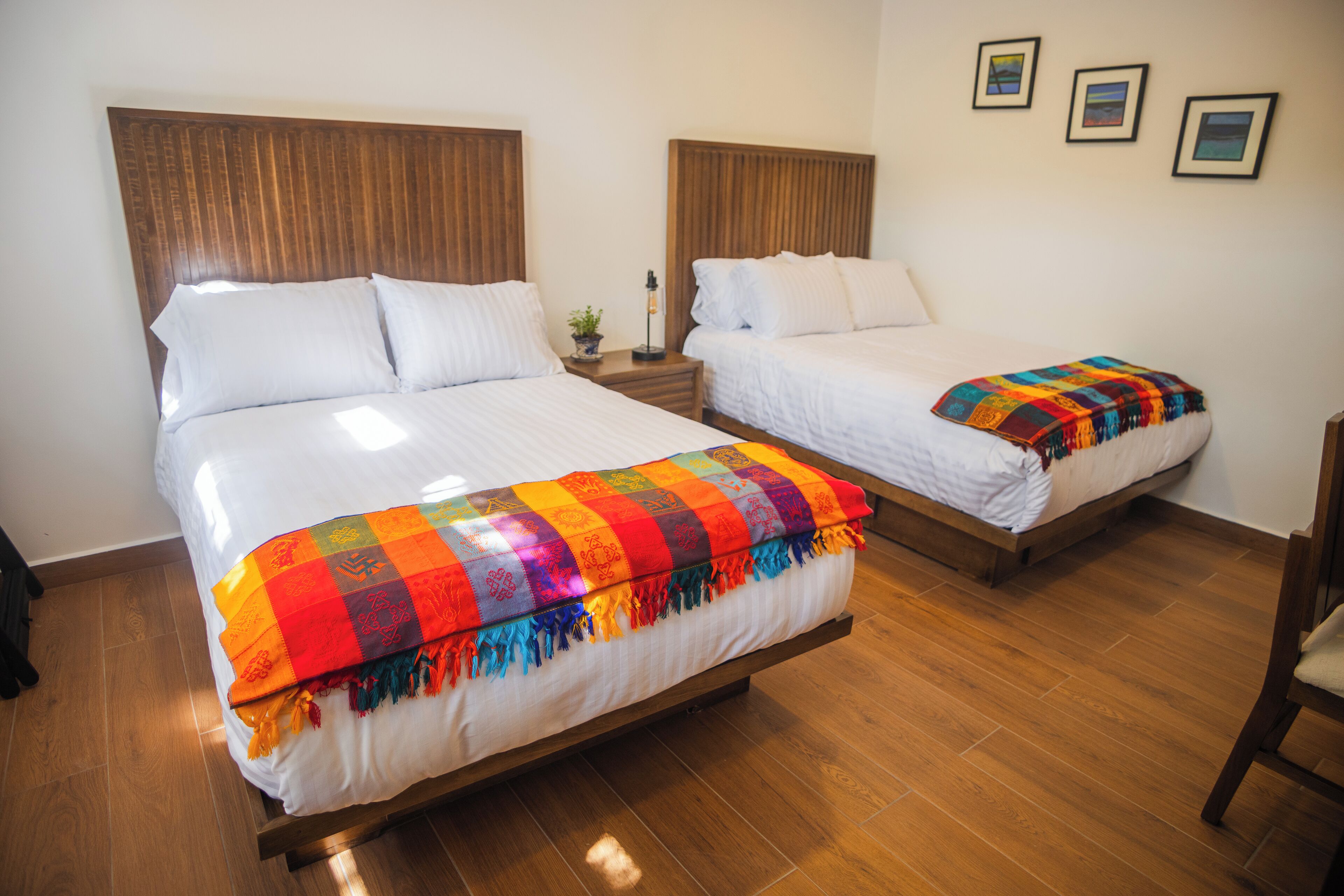 Two single beds with wooden headboards in a room with wooden flooring.