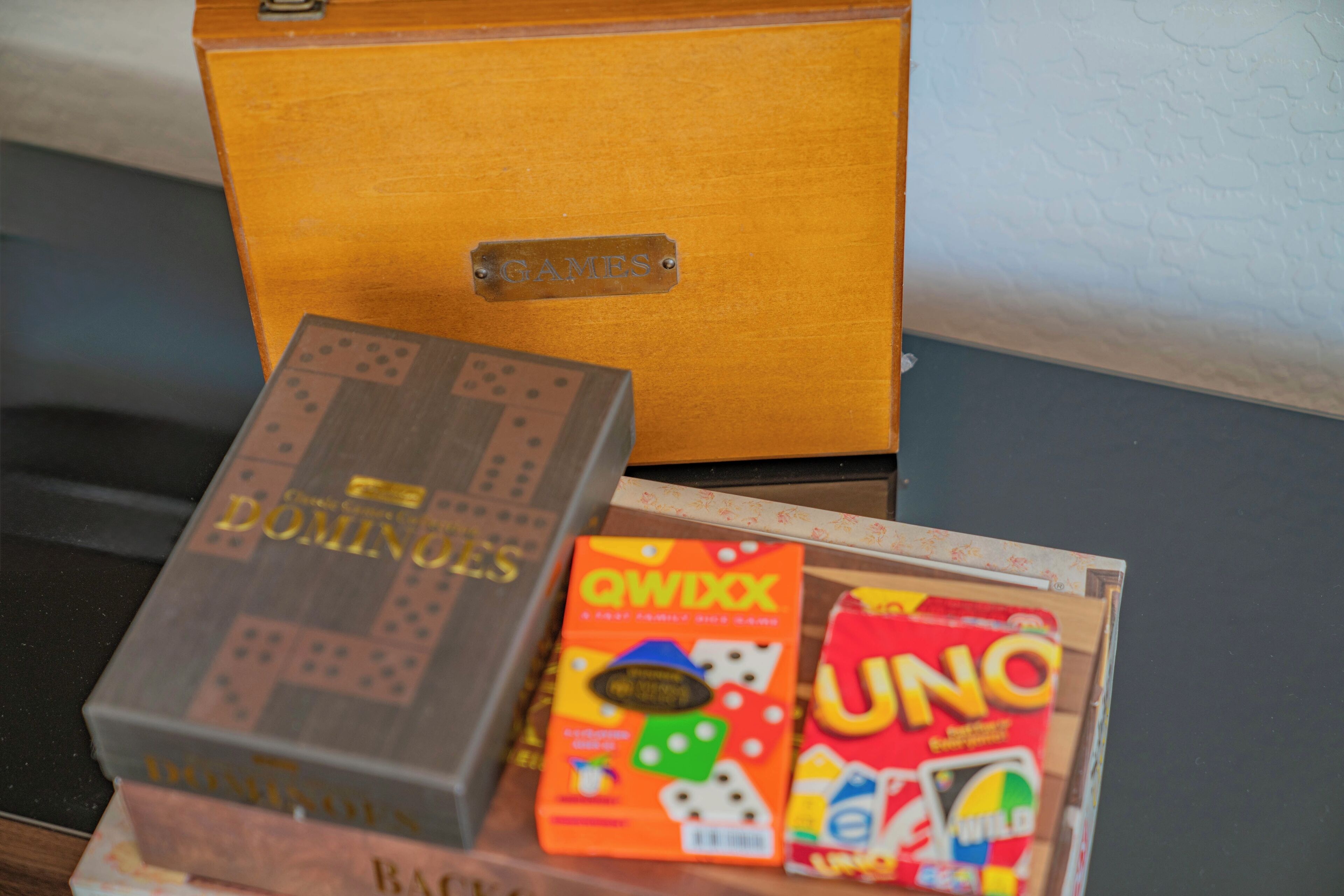 A wooden chest with a metal latch and a label reading "GAMES" on a table.