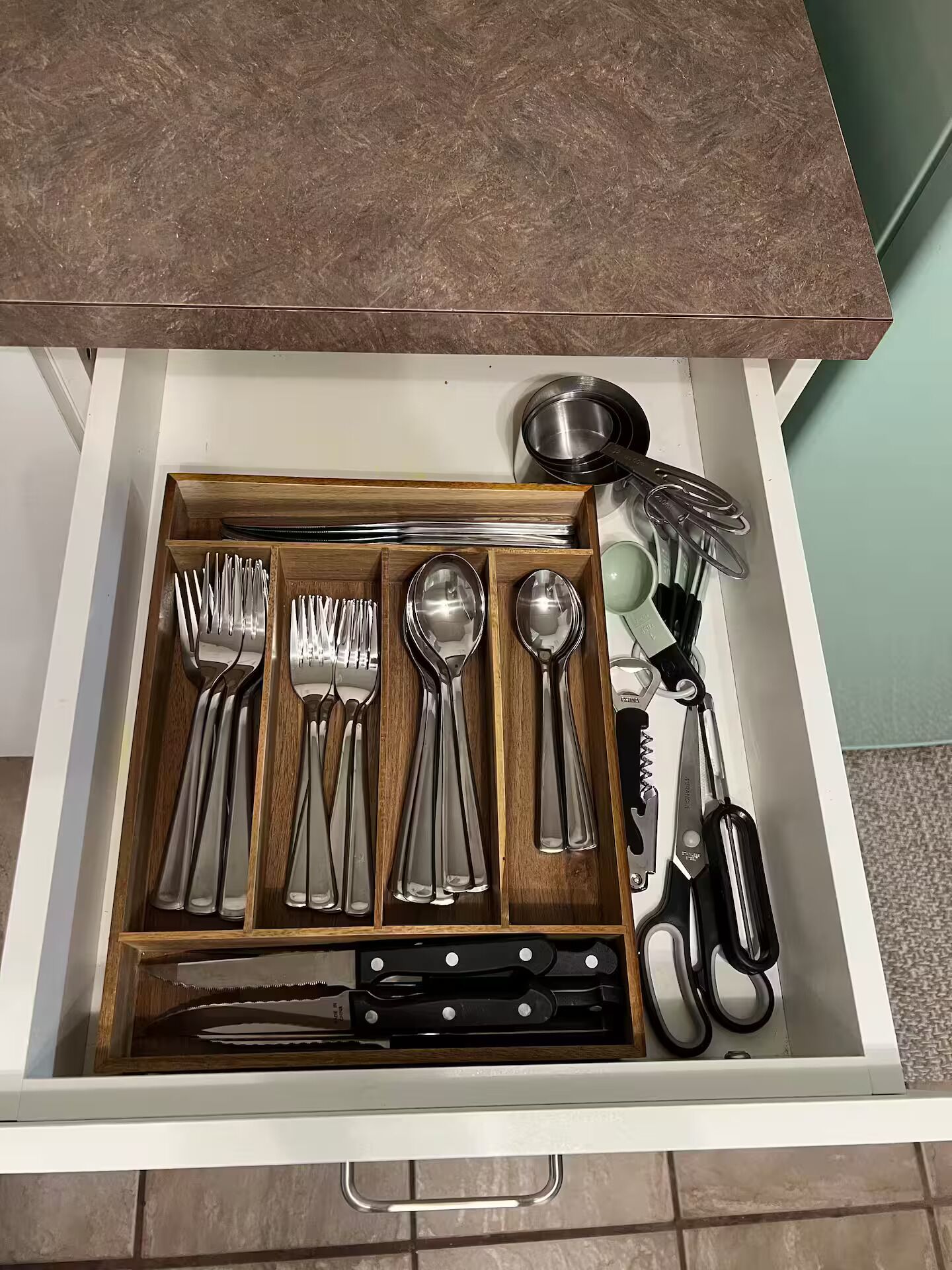 Un cassetto contenente posate, tra cui forchette, cucchiai e coltelli.