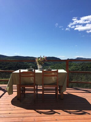 Une table dressée à l’extérieur, offrant une vue sur un paysage montagneux.