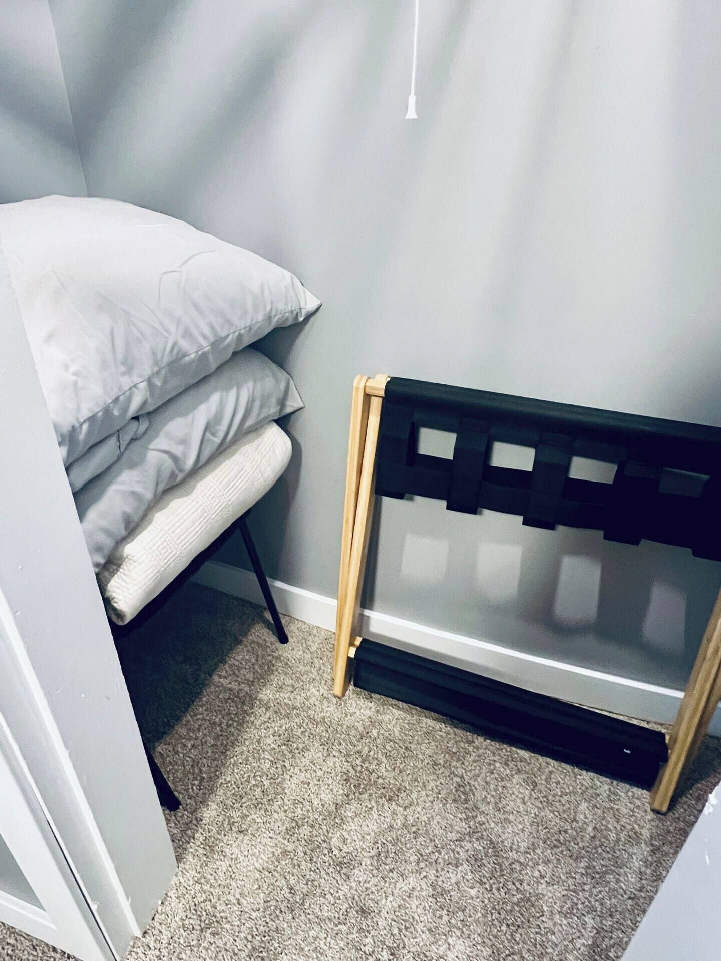 A corner of a room with a bed, a small table, and a radiator.