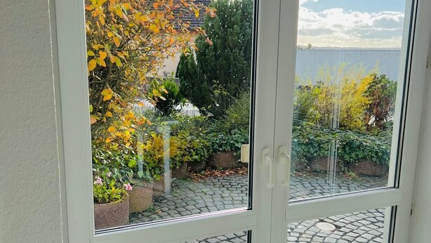 Una habitación con vista a un jardín y un sendero empedrado.