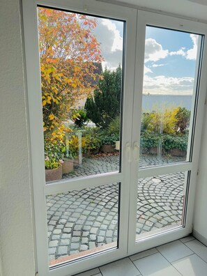 Una habitación con vista a un jardín y un sendero empedrado.