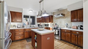 Een moderne keuken met houten kastjes, roestvrijstalen apparatuur en een centraal eiland.