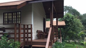 Une terrasse en bois avec un escalier menant à un porche abrité.