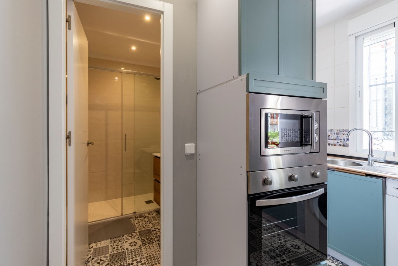 A compact kitchen with a built-in oven, a microwave, and a sink.