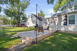 A backyard with a wooden deck, a grill, and a covered patio area. - Walk to Stadium & Campus -4BR with Game Room (Columbus)