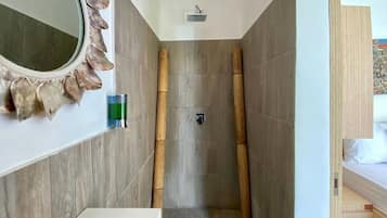 Ein Badezimmer mit Dusche, Waschbecken und Spiegel.