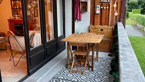 A patio with a patterned floor, a wooden table, and chairs. - Christmas Apt | Parking + Balcony | Near Center (Morzine)