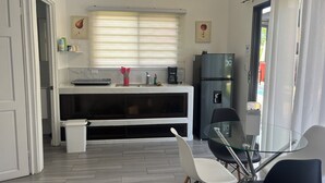 A modern kitchen with a refrigerator, a coffee maker, and a window with blinds. - Charming 1-bedroom villa in superb Bahia with AC (Bahia)