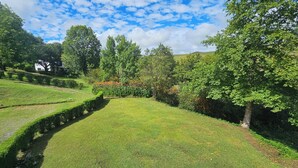 A landscaped garden with manicured lawns, hedges, and trees. - eMkhosini Royal Sun (Underberg)
