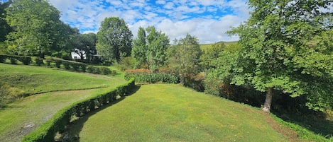 A landscaped garden with manicured lawns, hedges, and trees.