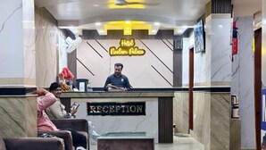 A hotel reception area with marble flooring, a reception desk labeled "RECEPTION," and a chandelier. - Hotel Neelam Palace (New Delhi)