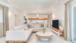 En moderne stue med sofa, sofabord og fjernsyn.