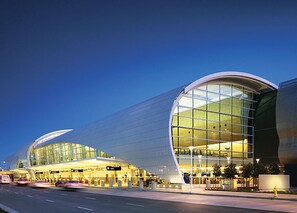 A modern airport terminal with a curved glass facade and a spacious interior. - Family and Business Friendly Home near Great Mall & BART - 2640 (San Jose)