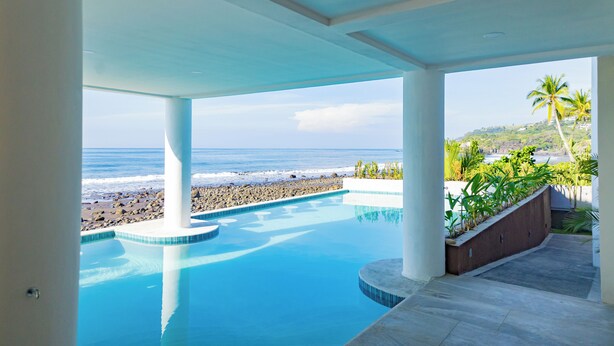 Una piscina con vistas a la playa y al océano.