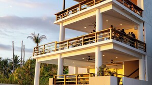 Un edificio de varios pisos con balcones, una escalera y una zona de piscina.