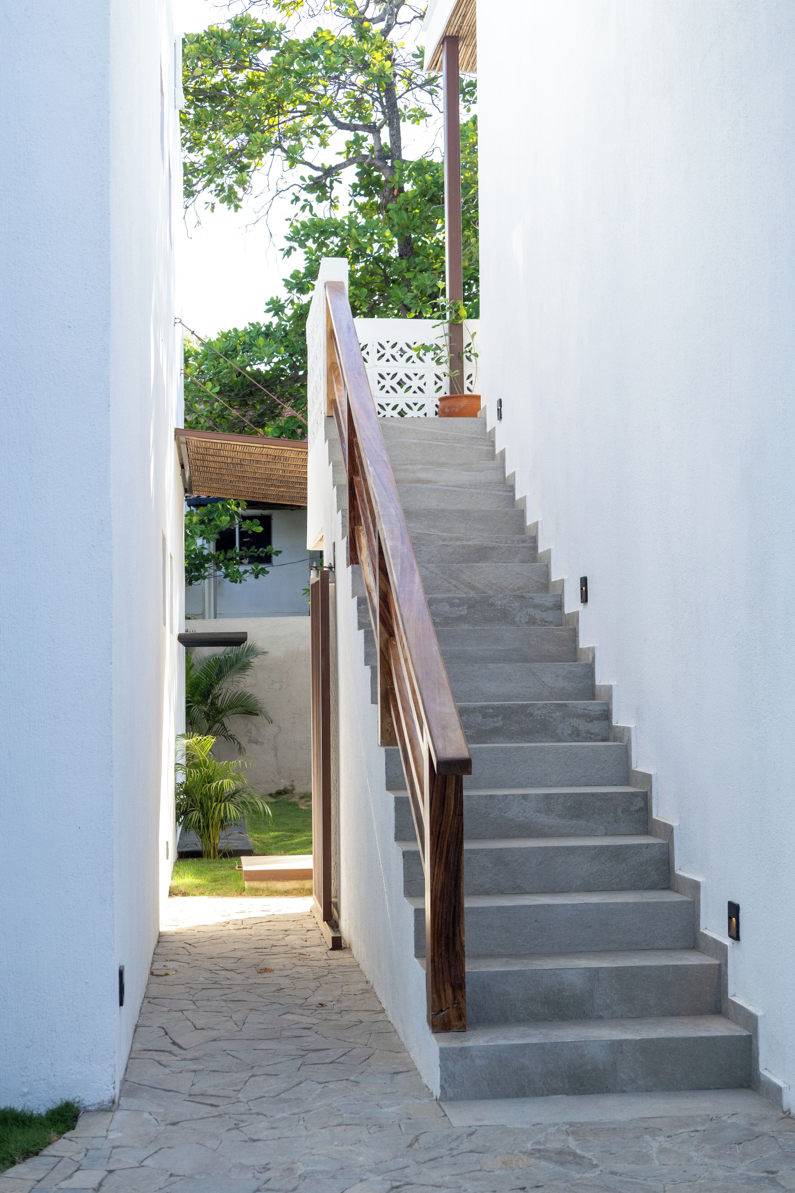 A staircase with a wooden handrail leading to a landing.