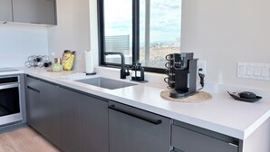 A modern kitchen with a large window, stainless steel appliances, and a coffee maker. - Relaxing Wine Country Stay - Hot Tub - Agave Farm (Temecula)