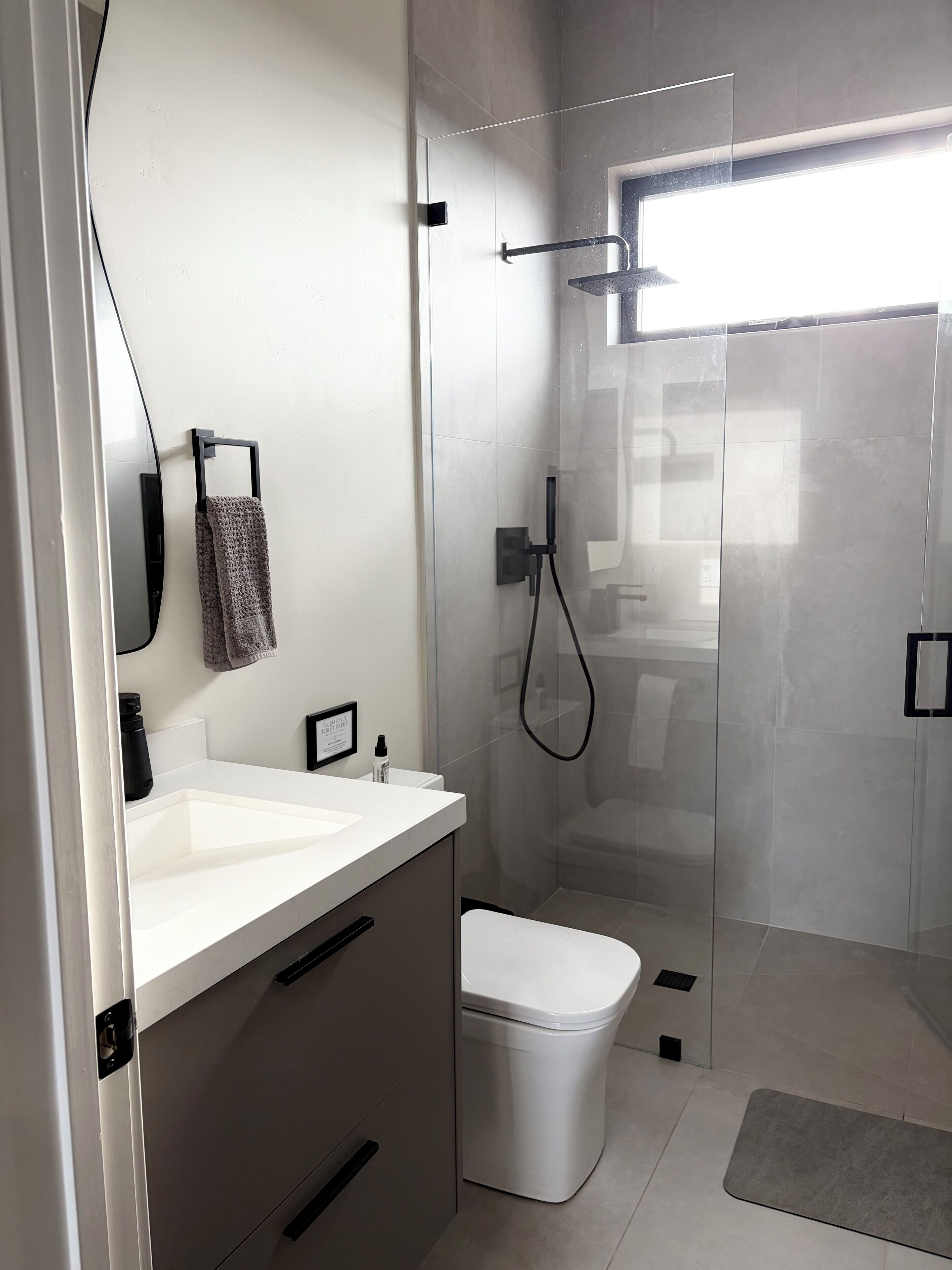 Un bagno moderno con doccia vetrata, lavandino bianco e water.