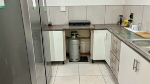 Una cocina equipada con estufa a gas, refrigerador y lavaplatos.