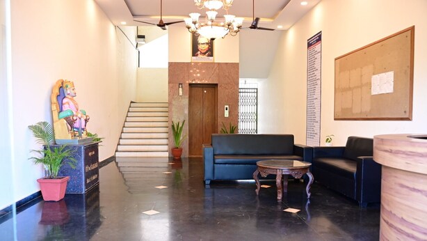 Un hall d’hôtel avec un escalier, un espace salon et un comptoir d’accueil.