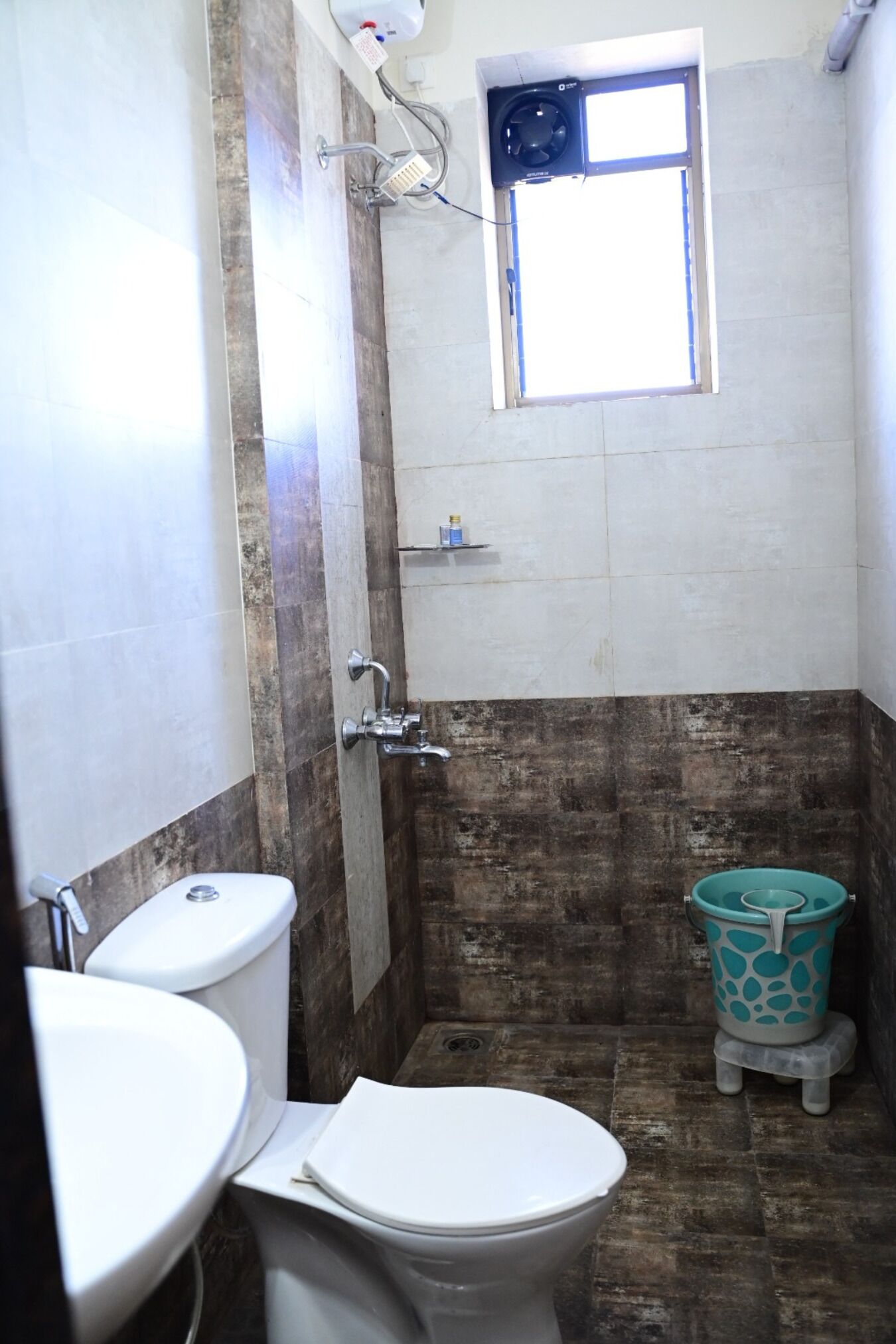 Un baño con inodoro, ducha y ventana.