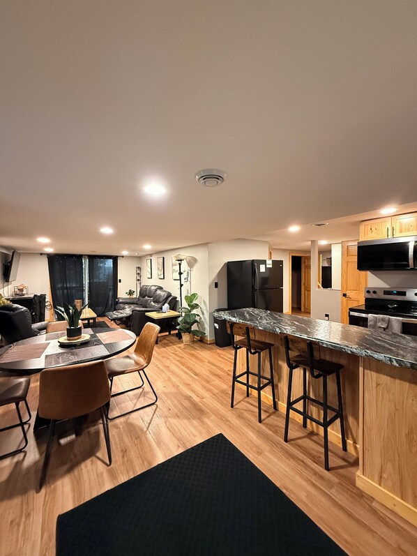 A modern kitchen with a marble countertop, wooden cabinets, and a built-in oven.