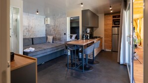 Une cuisine compacte comprenant un coin repas, une cuisinière intégrée et un réfrigérateur.