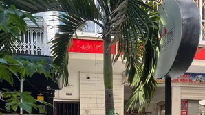Un bâtiment avec un auvent rouge, une porte en métal et une enseigne sur laquelle on peut lire « COSTA ».