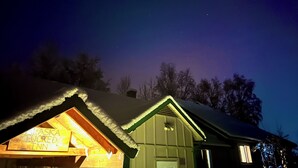 A snow-covered building with a lit interior, a visible sign reading "Alaska Snowed Inn," and a clear night sky with stars. - Alaska Tucked Inn-The Den ; Cozy 1 bedroom with all the touches of home! (Fairbanks)