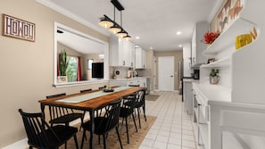 A modern kitchen with white cabinets, a wooden dining table, and black chairs. - Lake Access and Pool in the heart of Domain (Austin)
