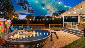 A hot tub with a wooden deck, outdoor furniture, and string lights. - Lake Access and Pool in the heart of Domain (Austin)