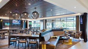 A modern hotel lobby with a bar area, seating arrangements, and large windows offering natural light. - SpringHill Suites by Marriott Bryce Canyon (Bryce Canyon)
