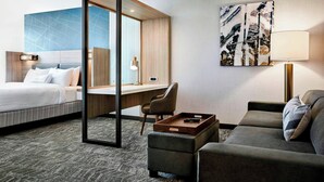 A hotel room with a bed, a desk, a sofa, and a large abstract painting on the wall. - SpringHill Suites by Marriott Bryce Canyon (Bryce Canyon)