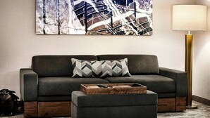 A modern living room with a grey sofa, a matching ottoman, a wooden tray, and a floor lamp. - SpringHill Suites by Marriott Bryce Canyon (Bryce Canyon)
