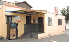 A building with an office sign, a vending machine, and a storefront. - Parklane Motel (Oakland)
