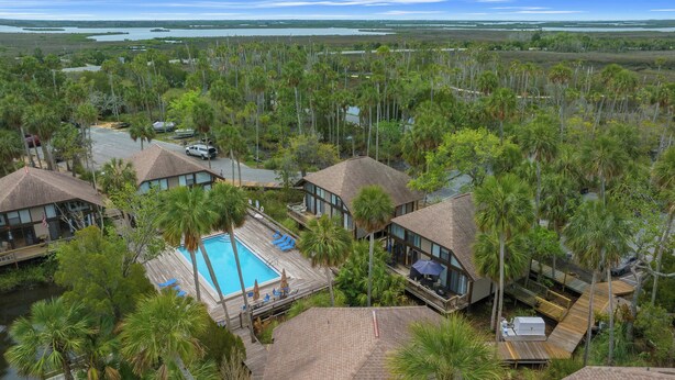 A resort with multiple buildings, a swimming pool, and a view of the surrounding landscape. - B1 - Riverview Bungalow (Crystal River)