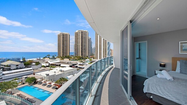 Ein Balkon mit Blick auf einen Pool und hohe Gebäude.