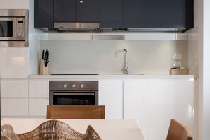 A modern kitchen with stainless steel appliances, a built-in oven, and a microwave. - Deluxe Two Bedroom Hilton Apartment (Surfers Paradise)