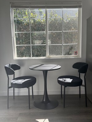 A room with a window, two chairs, and a small table. - Bright & Modern Bixby Knolls Studio + In-Unit W/D (Long Beach)